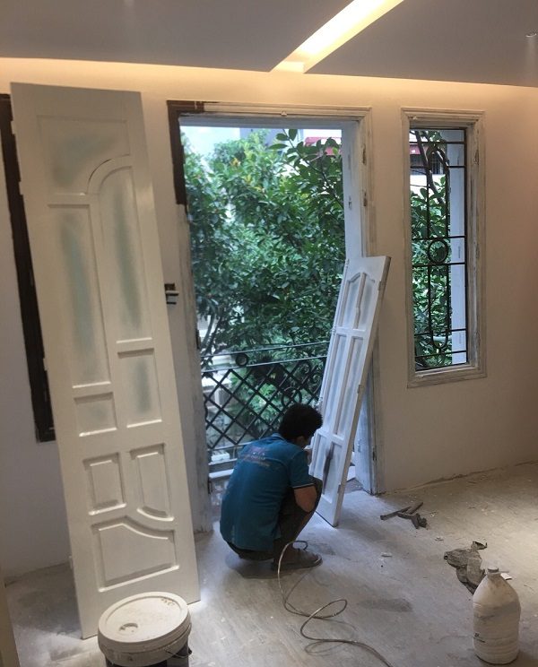 Thợ sơn cửa gỗ màu trắng tại Triệu Việt Vương, Bùi Thị Xuân, Hà Nội